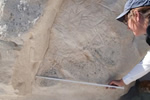 Laurie White is measuring a panel of Castle Gardens petroglyphs